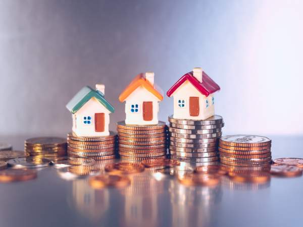 Miniature,Colorful,House,On,Stack,Coins,Using,As,Property,And - Shutterstock