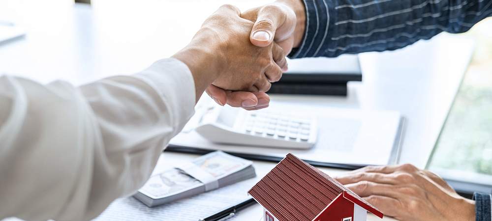 Real estate agent and customers shaking hands together celebrating finished contract after signing about home insurance and investment loan, handshake and successful deal. 
- © Shutterstock