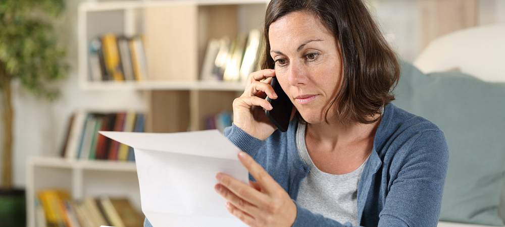 <p>Serious adult woman checking letter calling on smart phone sitting in the livingroom at home</p> 
- © Shutterstock