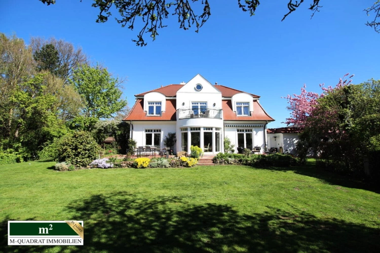Gartenseitiger Blick auf die Villa mit Mansarddach