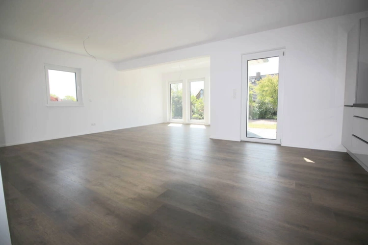 Blick in den Wohnbereich mit bodentiefen Fenstern u. Terrassenzugang