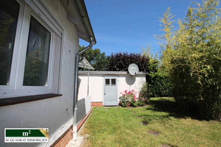 Gartenblick auf Garage mit Nebeneingang