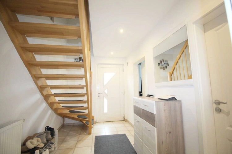 Eingangsbereich mit Flur u. Holztreppe ins OG