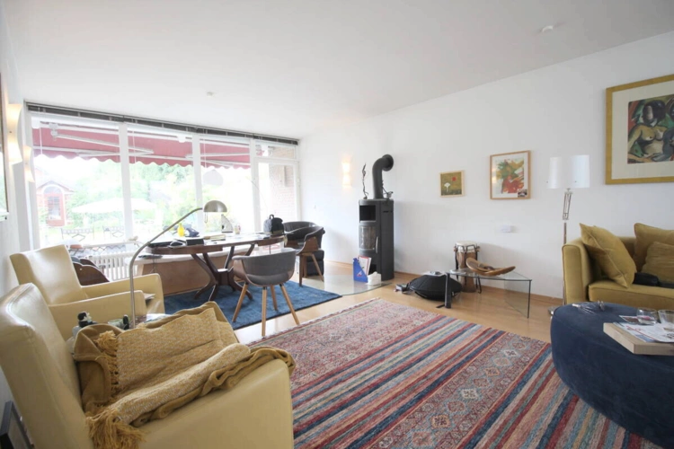 Wohnzimmer mit Panoramafenstern zum Garten u. Kamin EG