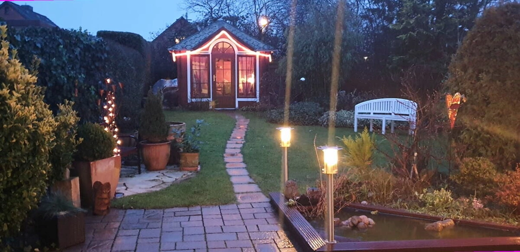 Beleuchteter Garten u. Gartenhaus am Abend