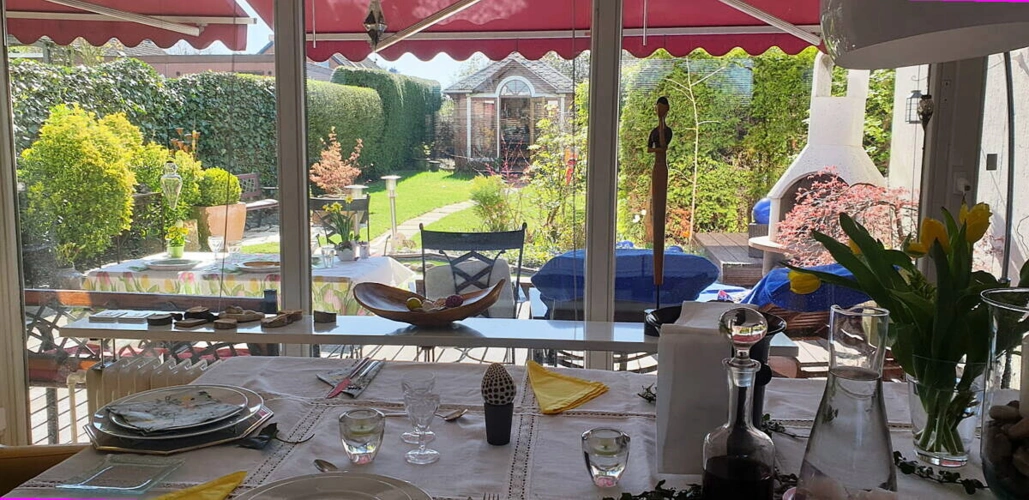 Blick aus Panoramafenstern des Wohnzimmers in den Garten